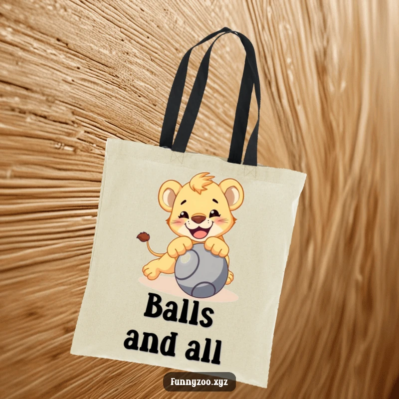 Funny lion cub tote bag, character playfully pouncing on a rolling ball, bold and practical, ideal funny gift.